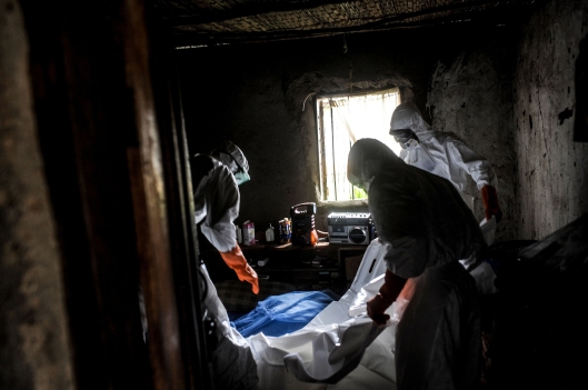 Health workers sterilize the house and prepare a body for burial in Lango village, Kenema, Sierra Leone. (Photo courtesy of Andalou Agency)